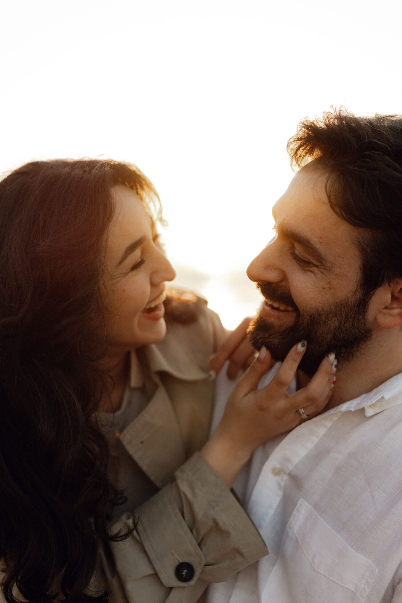 A smiling couple laughing together in warm light, the kind of connection high-achieving couples can rebuild.