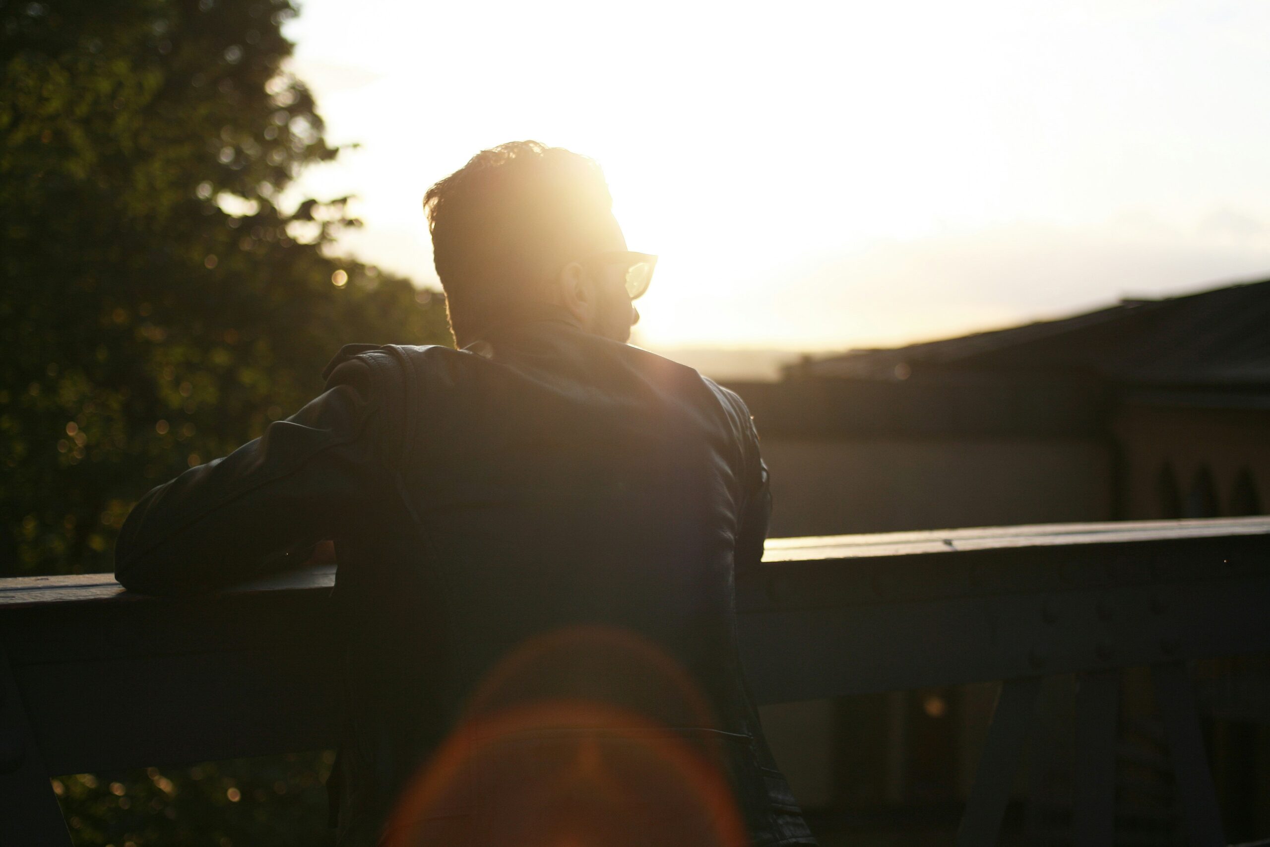 Man pausing on a balcony at sunset, reflecting on healing from unresolved trauma.